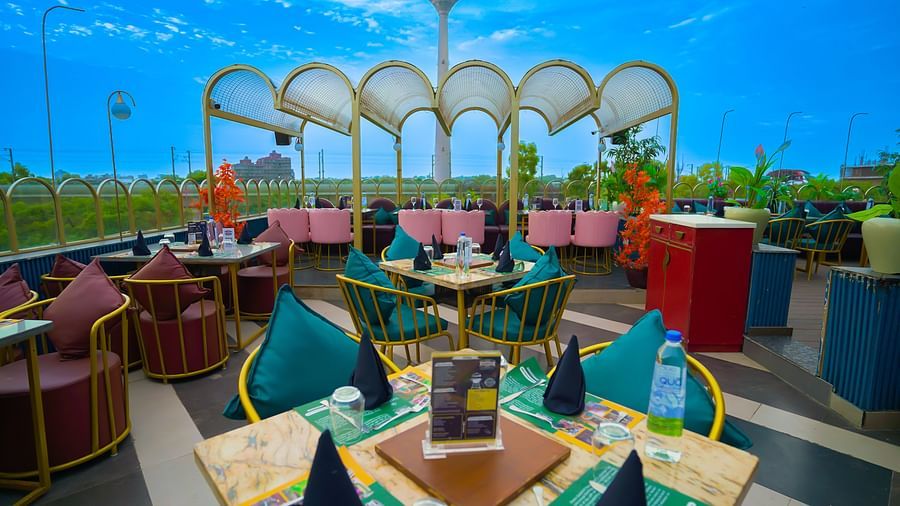 An image of an open restaurant set in a terrace of Themis Barbecue House, NSP Pitampura featuring chairs and tables in each corner 
