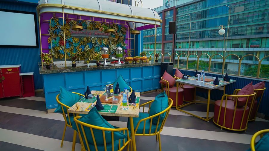 An image of a food counter along with a seating area at the rooftop of Themis Barbecue House, NSP Pitampura