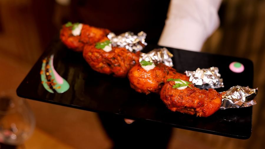 An image of chicken leg pieces grilled and garnished with green sauce - Themis Barbecue House, NSP Pitampura