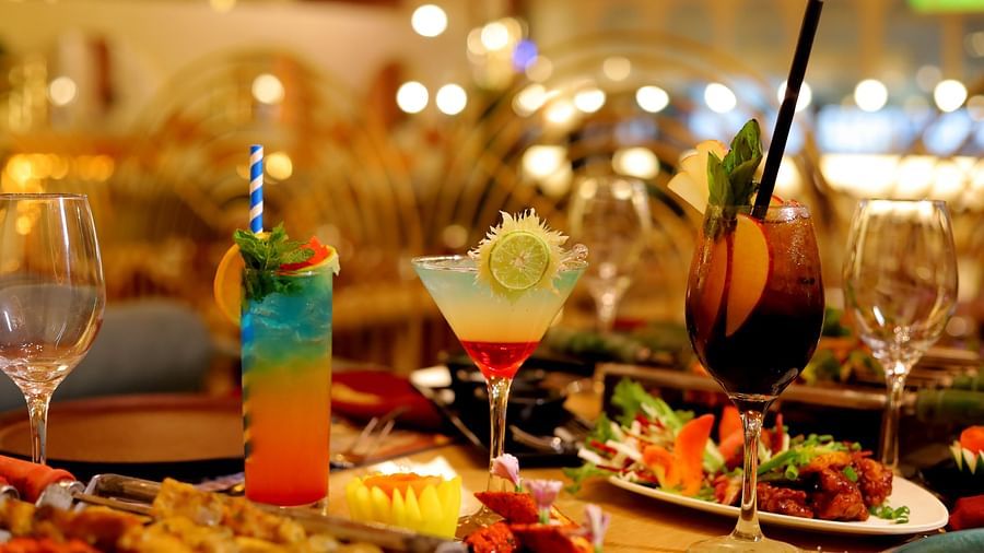 An image of a dining table where several food items are kept including drinks, barbecue grilled food, fitters, and other items - Themis Barbecue House, NSP Pitampura
