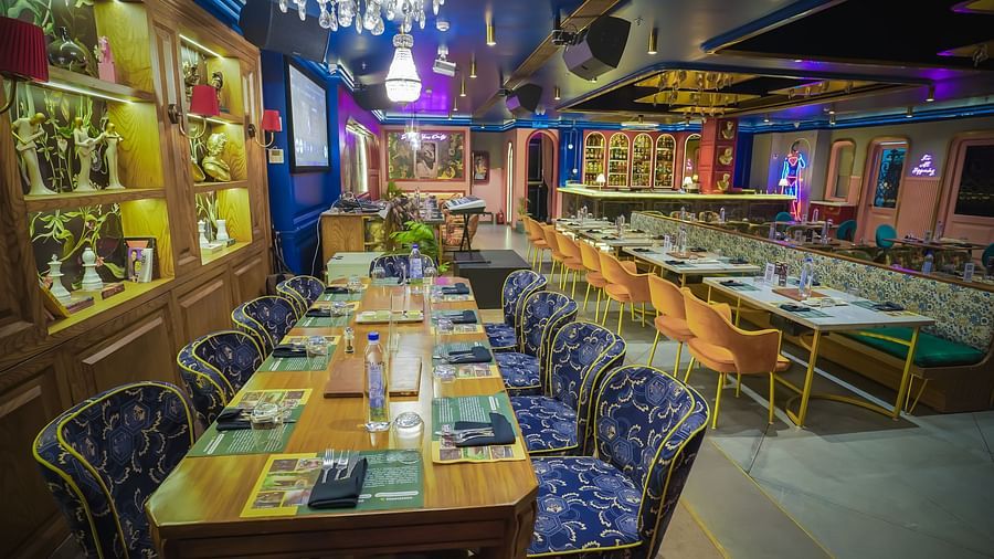Side view of the table at the restaurant with a portrait of a greek sculpture behind Themis Barbecue House NSP Pitampura