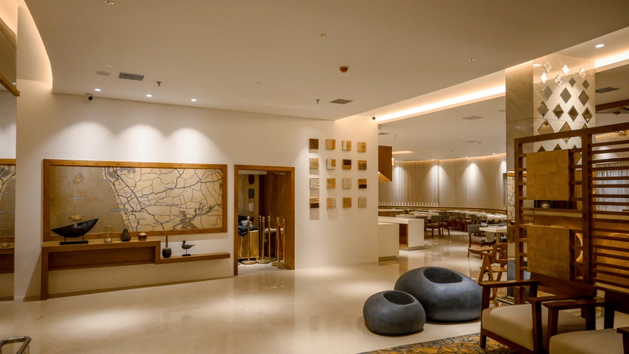 An indoor view of an illuminated lobby area with frames on the wall and seating arrangements at Tiara by MPS.