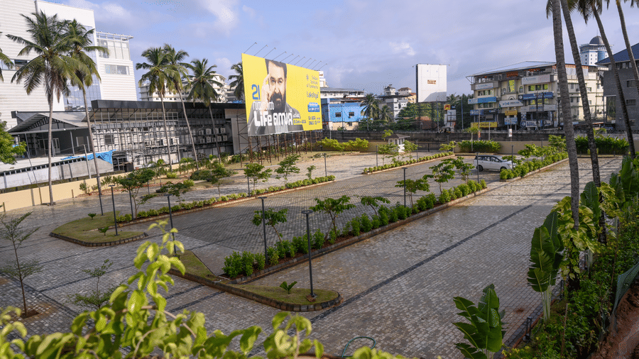 View of an expansive paved parking lot area next to palm trees and surrounding hotel structures at Tiara by MPS.