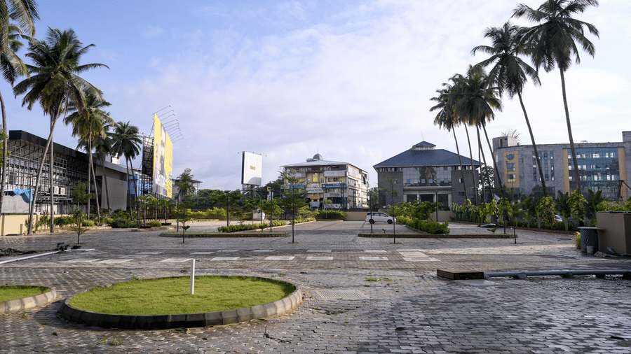 An outdoor open parking area surrounded by palm trees and buildings at Tiara by MPS.