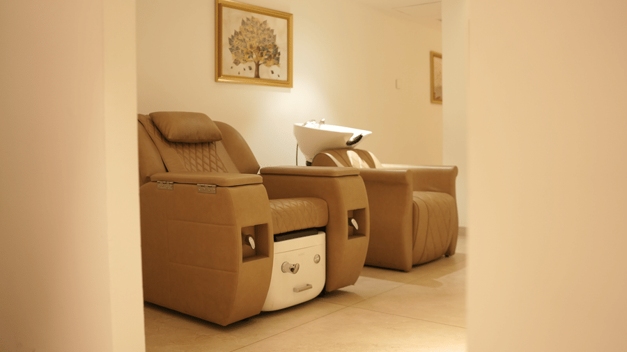 2 reclining salon chairs equipped with attached wash basins, mirrors, and wall art situated in a treatment room at Tiara by MPS.