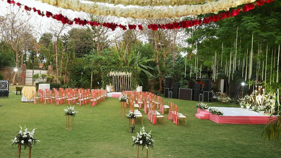 Lawn decorated for an outdoor function with floral canopy and seating at Tisya Farms, Gurgaon.