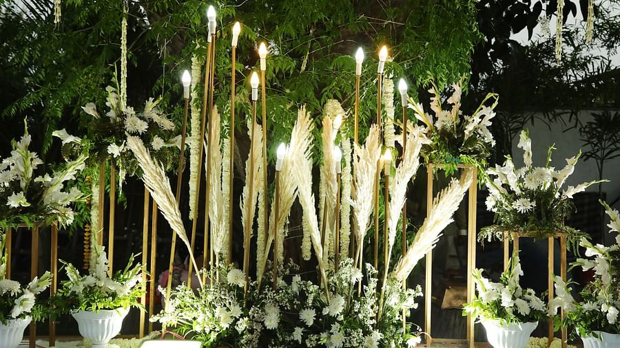 Decorative setup at Tisya Farms, Gurgaon with bamboo sticks, spotlights, and white flowers.
