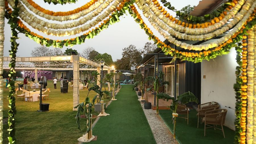 Venue entrance at Tisya Farms, Gurgaon with floral arch, green carpet, and guests walking inside.