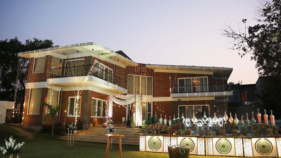 Main building of Tisya Farms, Gurgaon at dusk with lit landscaping and a clear view of the entrance area.