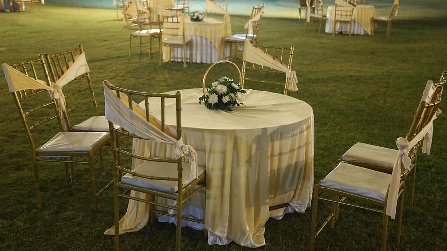 Round table setup with chairs in an open lawn event area at Tisya Farms, Gurgaon.