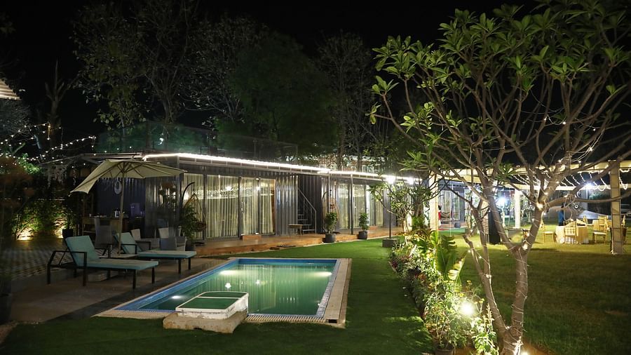 Outdoor venue with swimming pool and night lighting, set up for an event at Tisya Farms, Gurgaon.