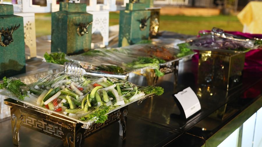Salad and vegetable station with covered trays and green containers at Tisya Farms, Gurgaon.