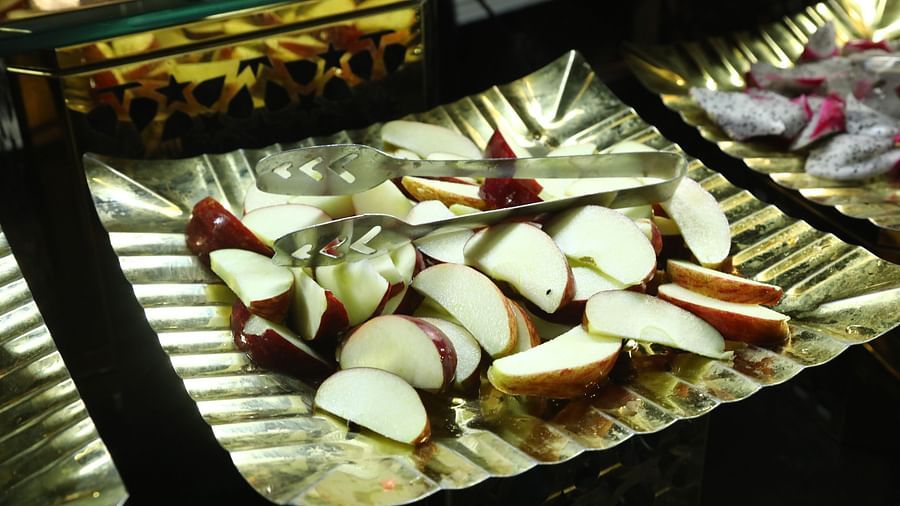 Sliced apples and radishes placed on a leaf plate at a food counter in Tisya Farms, Gurgaon.
