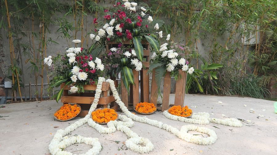 Wedding setup at Tisya Farms, Gurgaon with white garlands, orange marigolds, and red floral pillars.