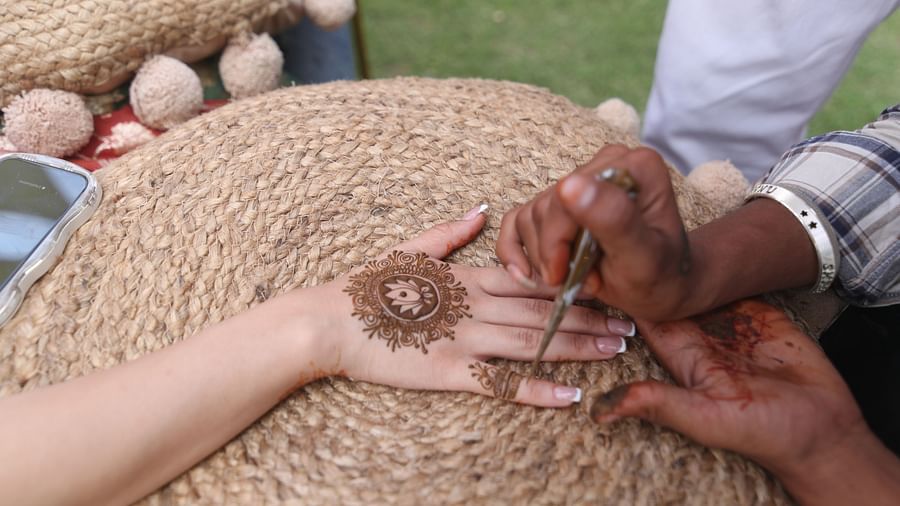 Close-up of applying mehendi on hand during a traditional ceremony at Tisya Farms, Gurgaon.