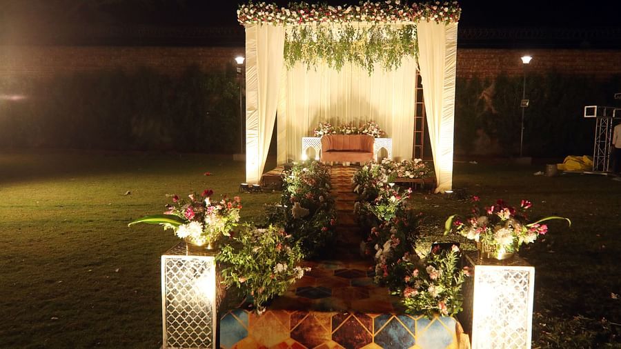 Wedding mandap with floral decor and seating arrangement on a lawn at Tisya Farms, Gurgaon.