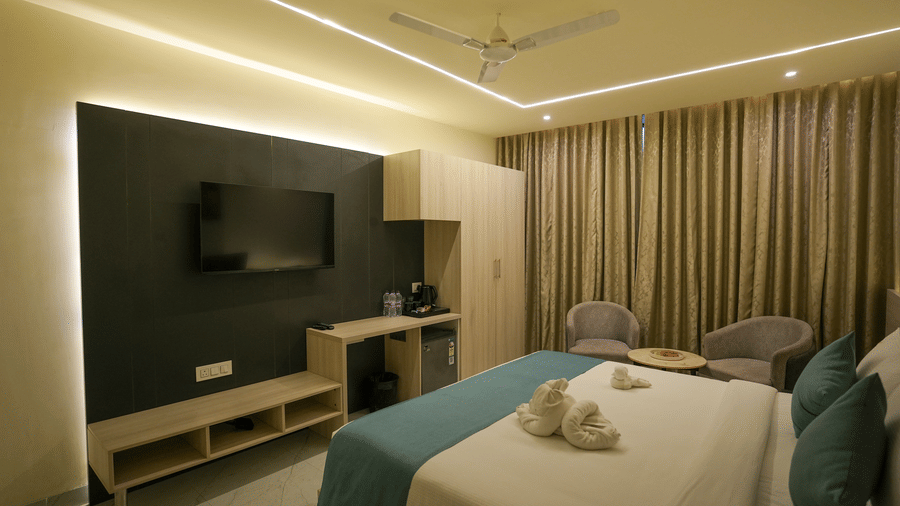 Starlight room with double bed, dark feature wall and flat-screen TV at Town Square Suites