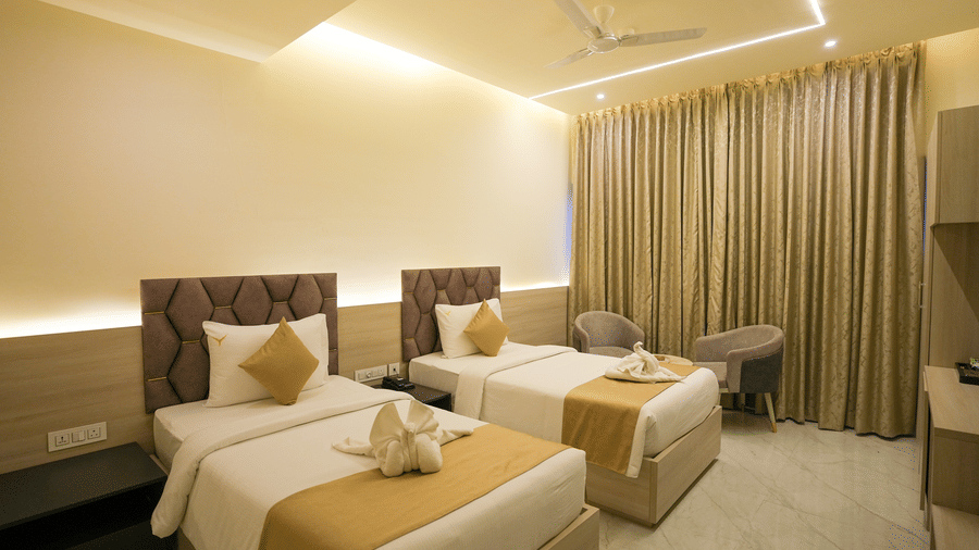Twin studio room with two beds, beige curtains and modern decor at Town Square Suites