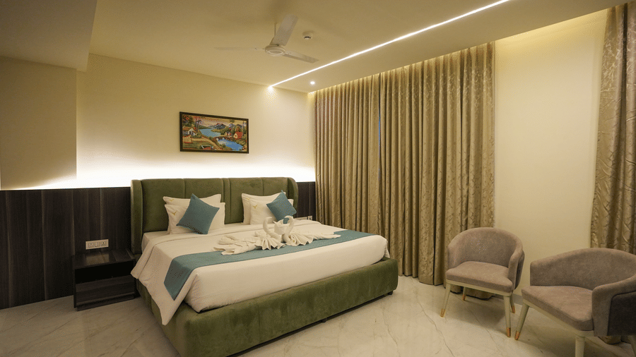 Comfortable bedroom at Town Square Suites with large bed, soft lighting, and modern furnishings.