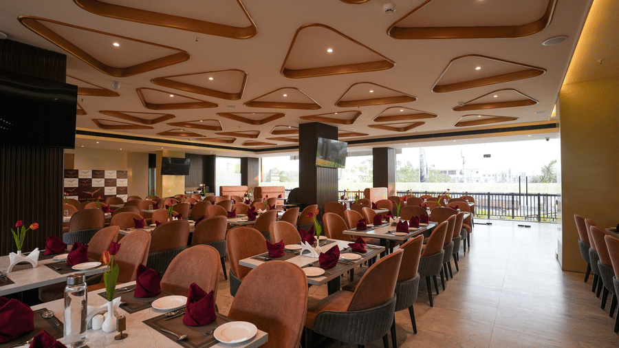 Spacious dining hall at Town Square Suites with neatly arranged tables and decorative ceiling.