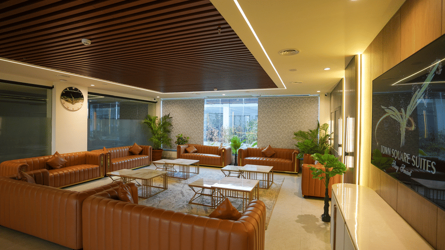 Stylish living space at Town Square Suites featuring sectional sofas, warm lights, and modern decor.