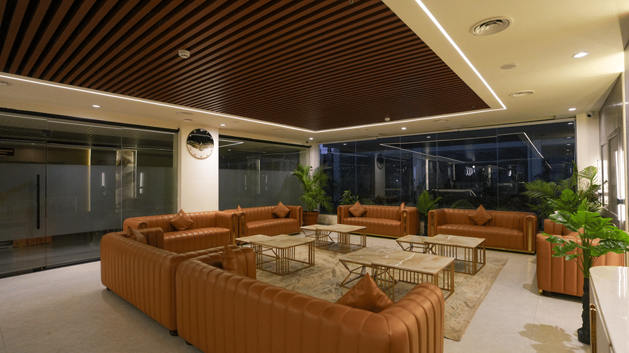 Wide view of lounge at Town Square Suites with plush seating, indoor plants, and contemporary design.