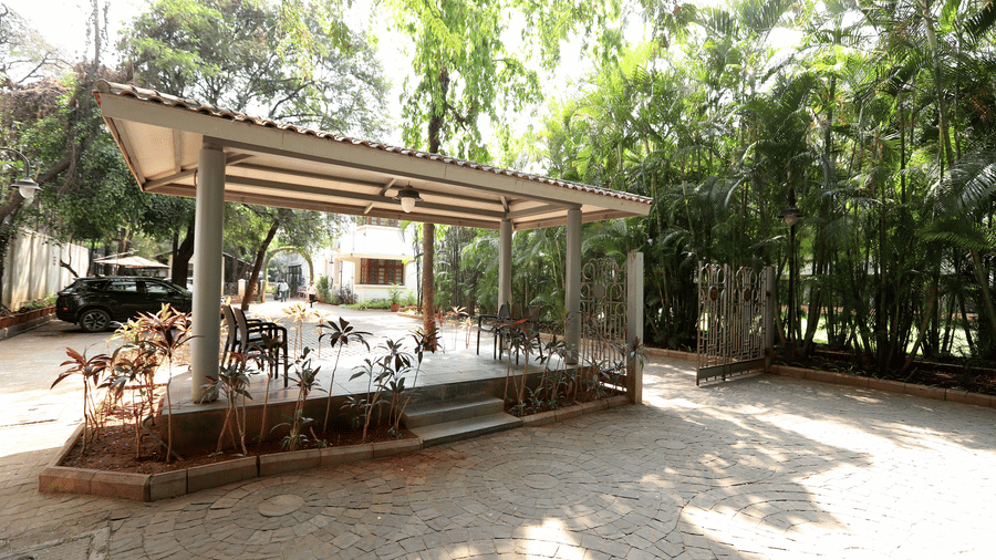 A view of the resort's clean, architectural facade overlooking a garden path with tropical landscaping | Trance Sunderban Resort