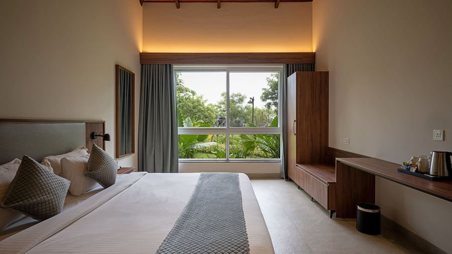 Spacious bedroom at Ananta Villa – 3-Bedroom Villa, Trance Veechika Resort, Vikarabad, with garden views and warm ambient lighting.