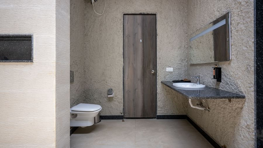 Ananta Garden Villa bathroom with a toilet, a sleek vanity with a sink, and a mirror.
