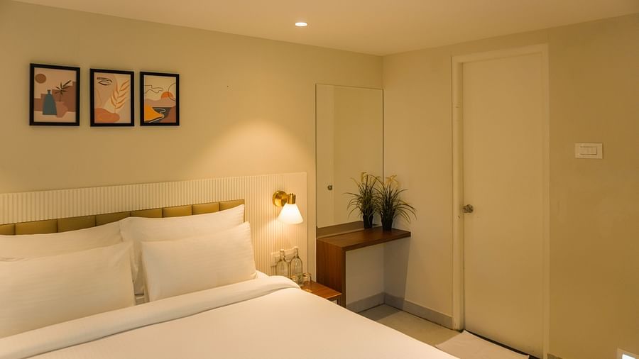 An image of Kalpa room with king size bed, side tables, and decorative items - Trance Veechika Resort