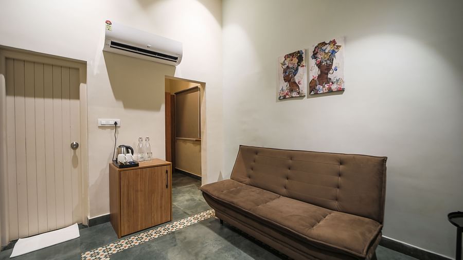 An image of room with separate living area with sofa and tea coffee maker - Trance Veechika Resort, Vikarabad