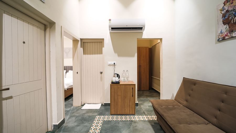 An image of room with separate living area with sofa and tea coffee maker - Trance Veechika Resort, Vikarabad