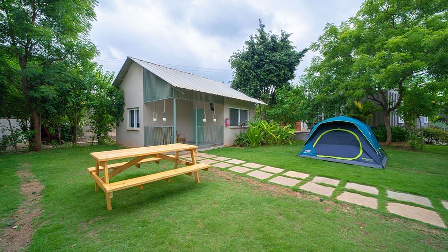 A facade image of a room with an outdoor seating arrangement and a tent - Trance Veechika Resort, Vikarabad