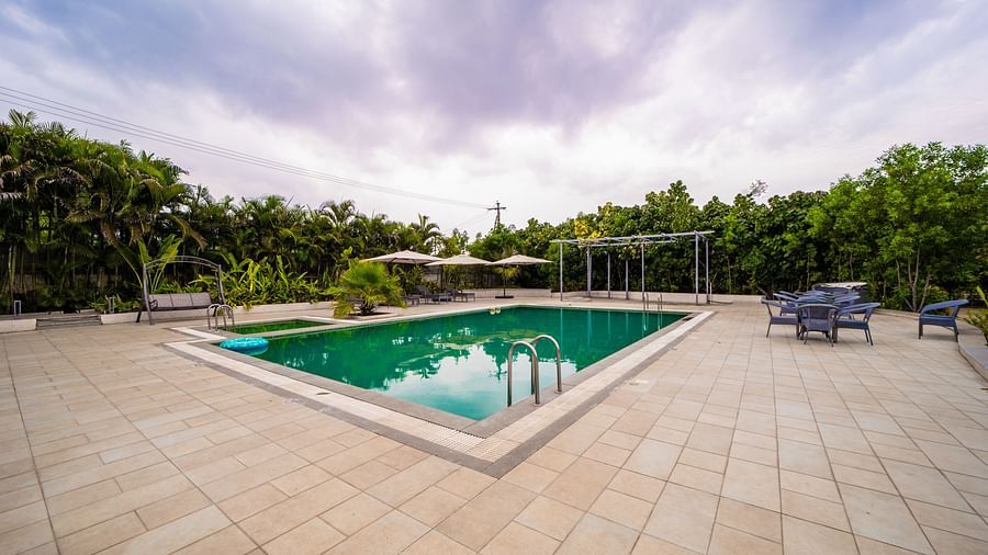 An image of a swimming pool with trees in the background - Trance Veechika Resort, Vikarabad