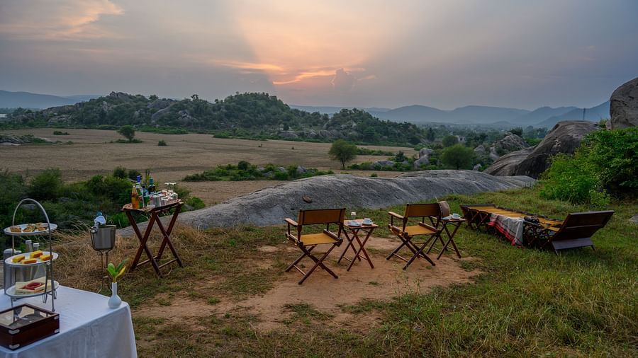 An image of an outdoor seating amidst greenery over viewing the mountains - Utsav Camp Sariska.