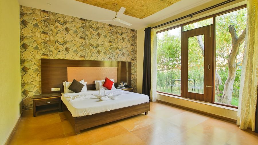 A room with a bed and a large glass wall and door on the side at Valley by Grassfield.