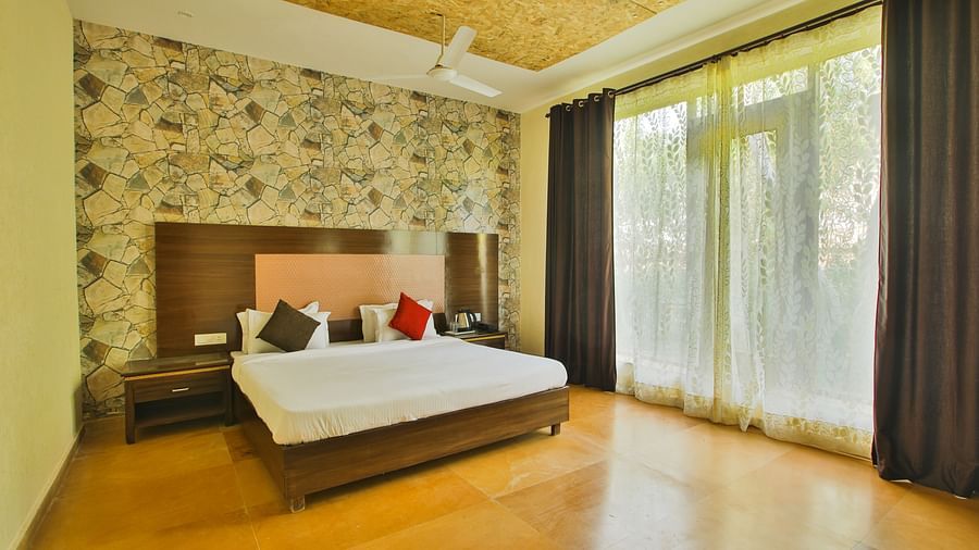 A room with a bed and a large window on the side at Valley by Grassfield.