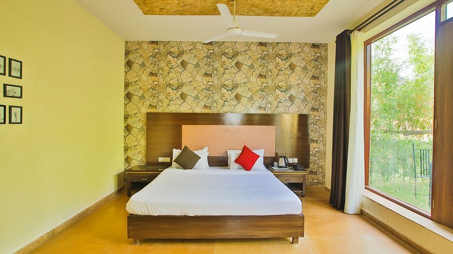 A room with a bed placed in the middle and a large window on the side at Valley by Grassfield.