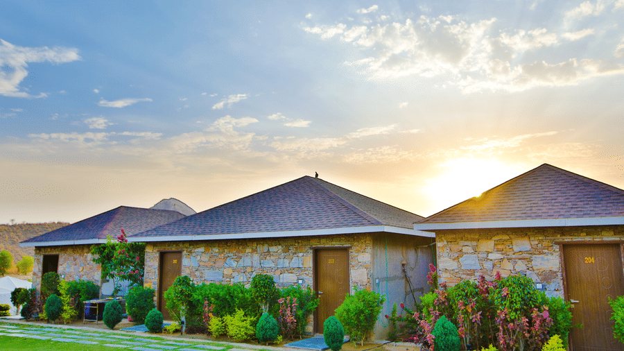 Cottage facade with plants growing in front at Valley by Grassfield, a resort in Jaipur.