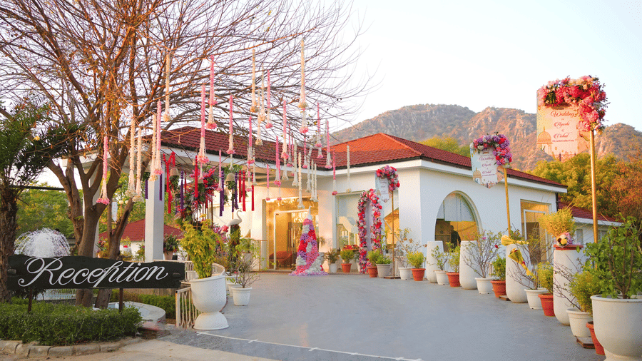 Entrance decorated with hanging florals and greenery for a wedding at Valley by Grassfield, a destination wedding resort in Jaipur.