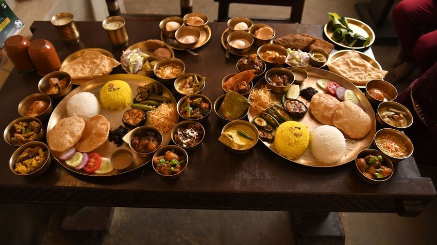 A wide shot of a large wooden table filled with an elaborate spread of various Indian thali dishesA wide shot of a large wooden table filled with an elaborate spread of various Indian thali dishes | Bhoomi Restaurant