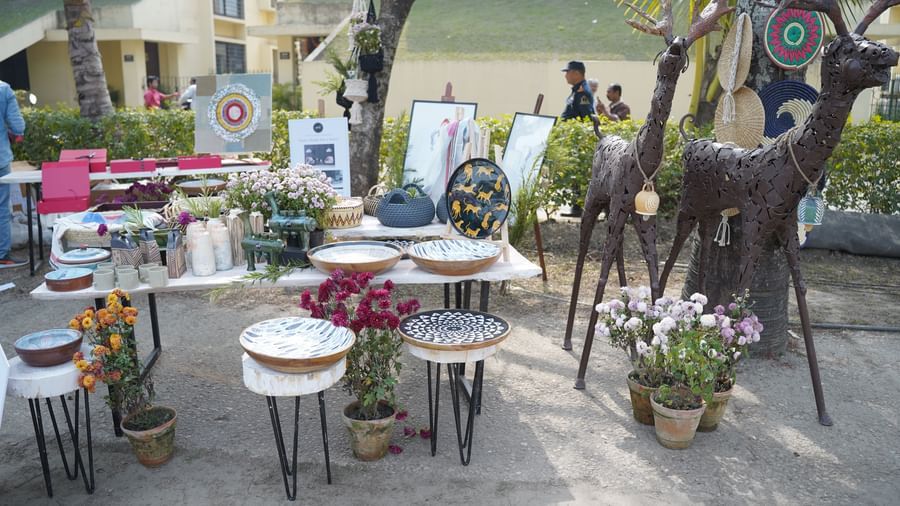 An outdoor scene features multiple white stools and small tables set up for an event, possibly a market | Vedic Village Spa Resort, Kolkata