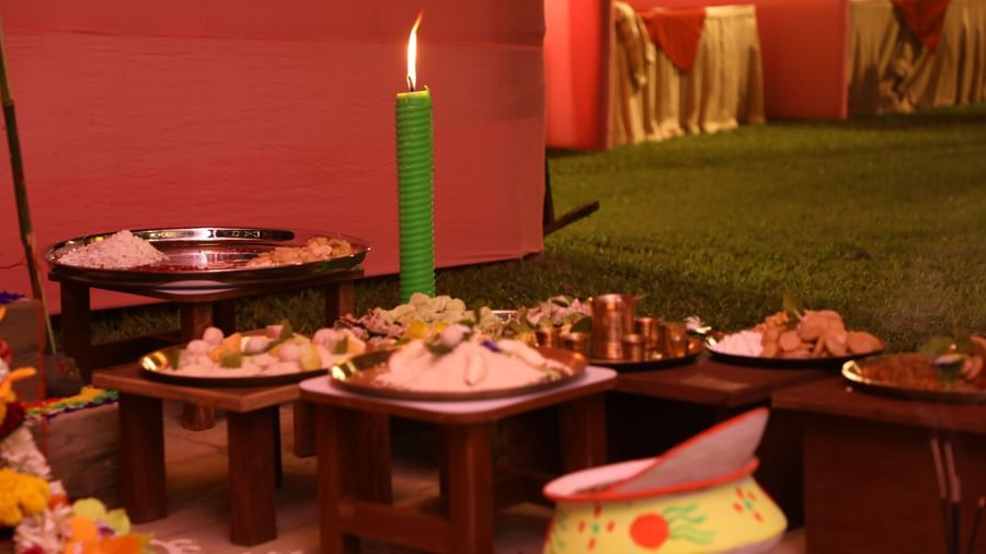 A buffet table is set with various dishes, including sweets and savoury items, illuminated by a green candle | Vedic Village Spa Resort, Kolkata