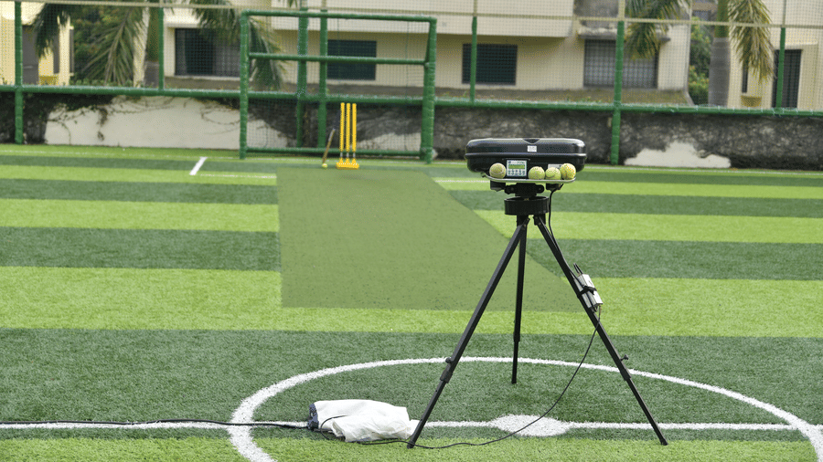 A telescope on a tripod placed on a green cricket ground with white boundary markings at Vedic Village Spa Resort.