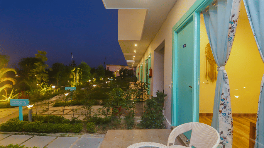 The exterior of rooms at Vedikant Resorts The Mallard Corbett at night shows balconies and illuminated pathways.