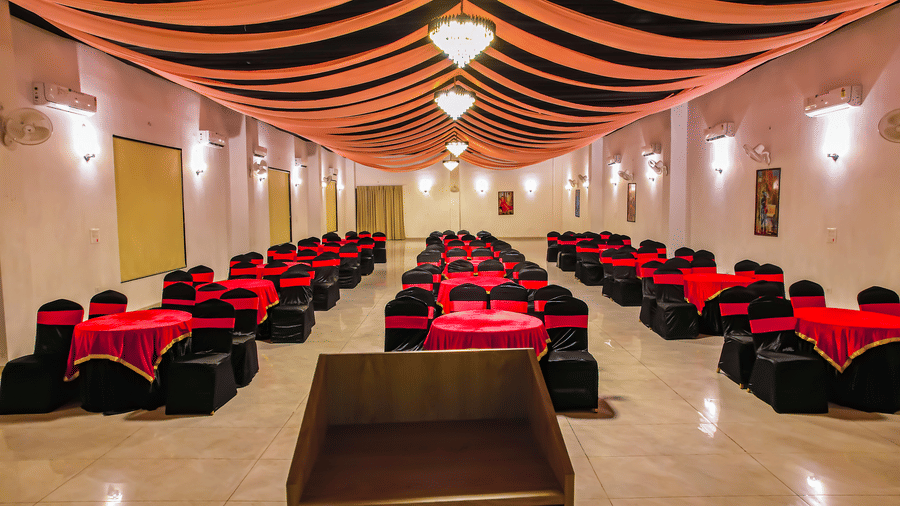 Another view of an empty banquet hall at Vedikant Resorts The Mallard Corbett displays rows of chairs and tables under a decorated ceiling.
