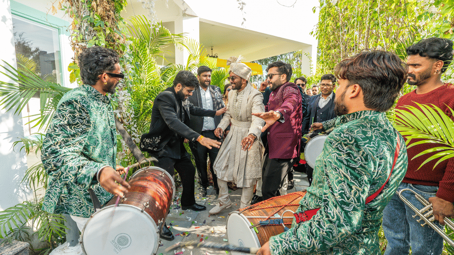 A group of Dhol players in matching green and black outfits performing live for guests at a wedding celebration at Vedikant Resorts The Mallard Corbett.