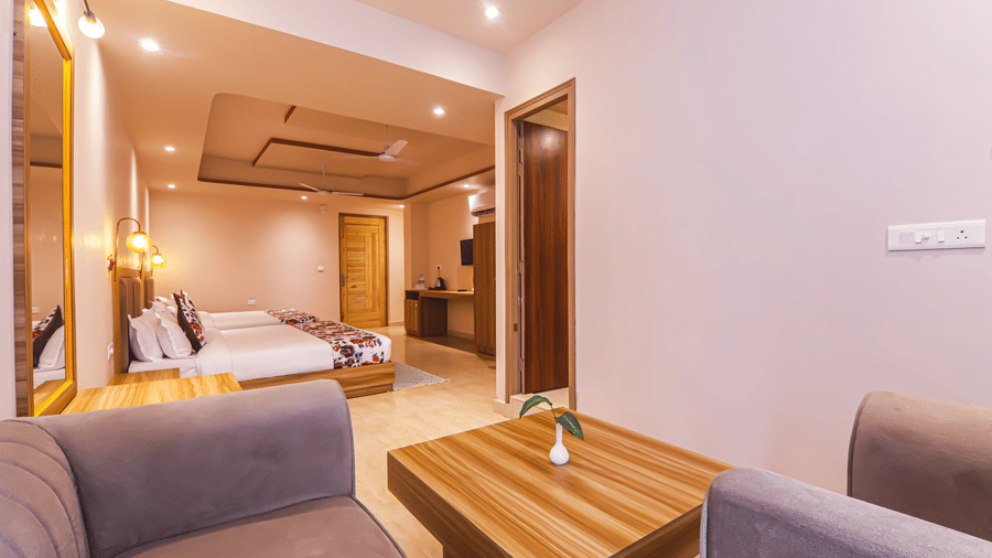 A cosy living area connects to a bedroom with multiple beds at Vedikant Resorts The Mallard Corbett.