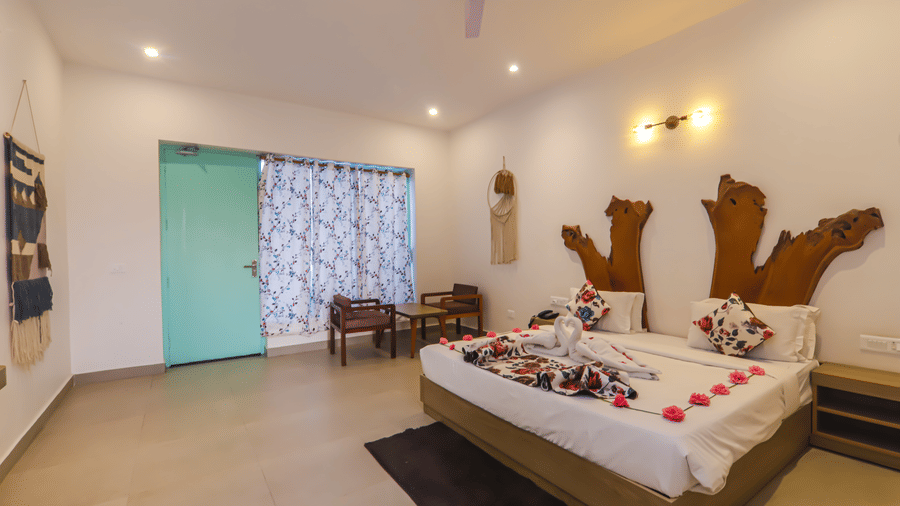 A bedroom at Vedikant Resorts The Mallard Corbett featuring a decorated bed, ample lighting and seating area.