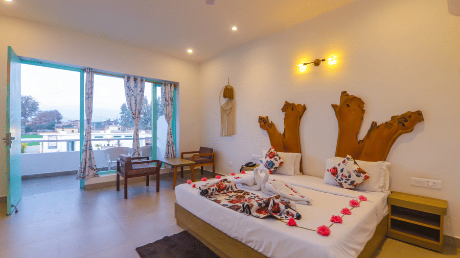 A uniquely decorated bedroom at Vedikant Resorts The Mallard Corbett features a bed adorned with flowers and seating.